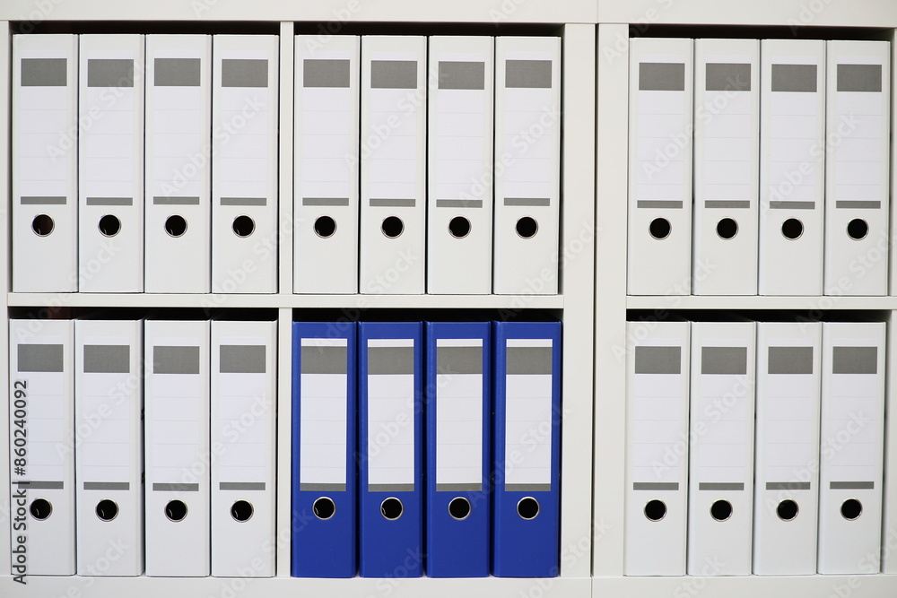 Aktenschrank mit weissen und blauen Aktenordnern Aktenschrank mit weissen und blauen Aktenordnern