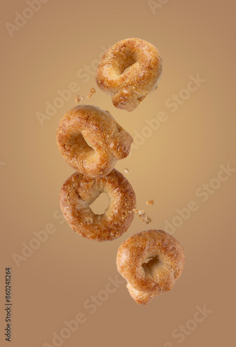 salty tarallini cookies flying on a beige background, food levitation