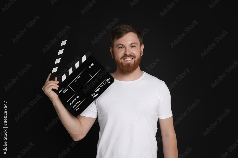 Making movie. Smiling man with clapperboard on black background Making movie. Smiling man with clapperboard on black background