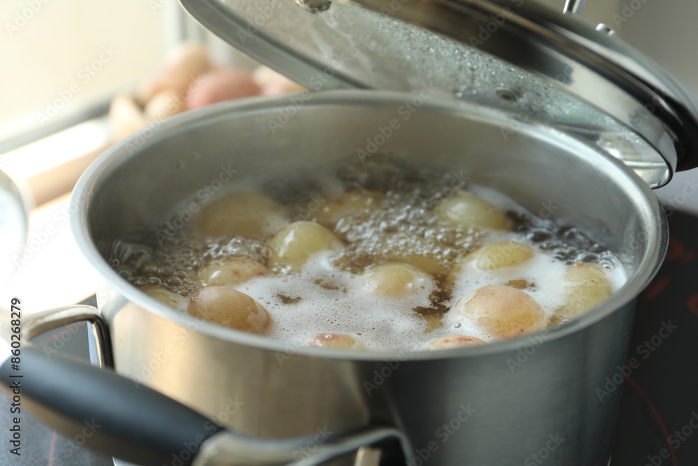 Boiling potatoes in pot on stove in kitchen, closeup Boiling potatoes in pot on stove in kitchen, closeup