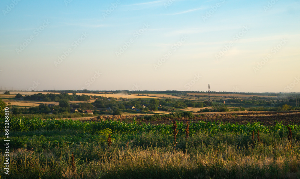 Landscape of a small village in the middle of a field. A small town in the middle of a field in the light of the evening sun Landscape of a small village in the middle of a field. A small town in the middle of a field in the light of the evening sun