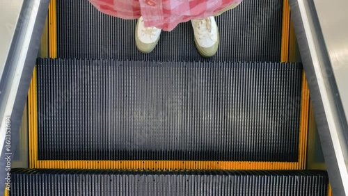 person standing on walking escalator