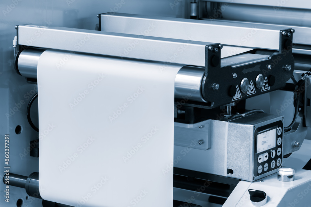 Automatic polyethylene plastic bag production machine with lighting effect. Close-up of the roller of the plastic bag production machine in the light blue scene. product packaging concept Automatic polyethylene plastic bag production machine with lighting effect. Close-up of the roller of the plastic bag production machine in the light blue scene. product packaging concept