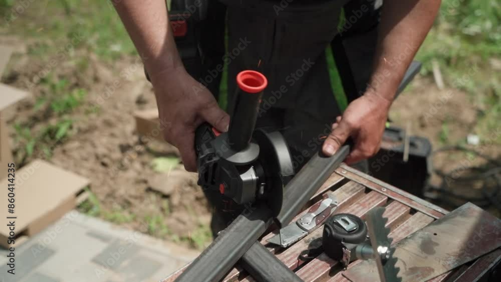 Worker cutting metal tube using an Angle Grinder. Bright sparks and flashes Worker cutting metal tube using an Angle Grinder. Bright sparks and flashes