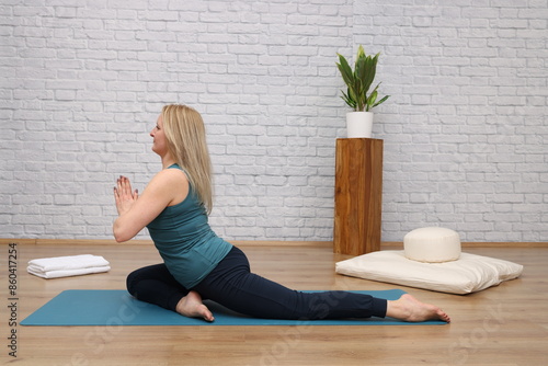 Frau beim Yoga im Yogastudio - half pigeon photo