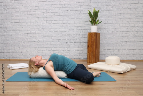 Obraz na plátně Frau beim Yoga im Yogastudio - reclining bound angle