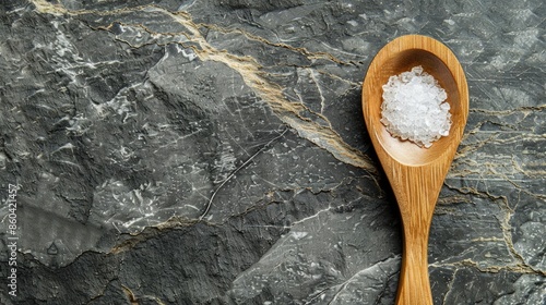 Close up of sweetener on wooden spoon on dark gray marble table with space for text photo