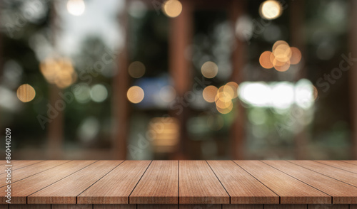 Empty wooden table top with lights bokeh on blur restaurant background.