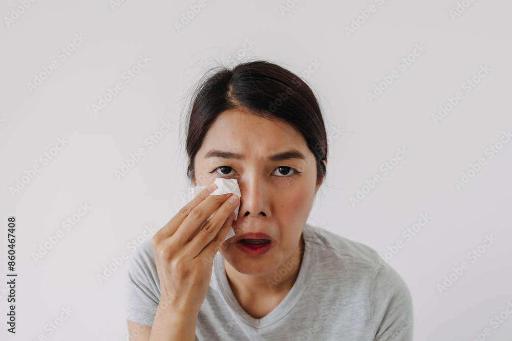 Asian Thai woman using tissue wiping her funny face, sweating in hot weather, standing isolated over white background wall. Asian Thai woman using tissue wiping her funny face, sweating in hot weather, standing isolated over white background wall.