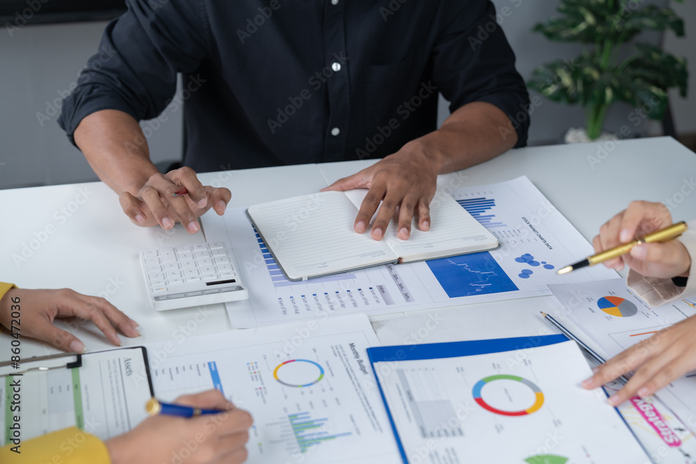 A photograph of a male and female employee's hands as they meet in an office, pens and laptops at the ready as they consult on business matters. A photograph of a male and female employee's hands as they meet in an office, pens and laptops at the ready as they consult on business matters.