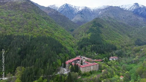 Wallpaper Mural Aerial view of the Rila Monastery in Bulgaria, surrounded by lush greenery against snow capped peaks in spring. Ideal for travel documentaries,  UNESCO World Heritage site. Torontodigital.ca