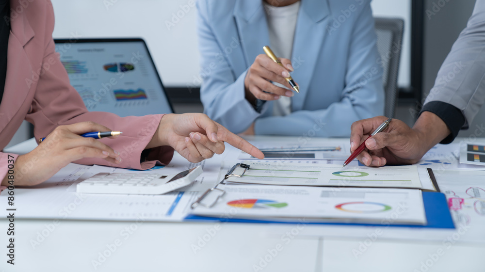 A photograph of a male and female employee's hands as they meet in an office, pens and laptops at the ready as they consult on business matters. A photograph of a male and female employee's hands as they meet in an office, pens and laptops at the ready as they consult on business matters.