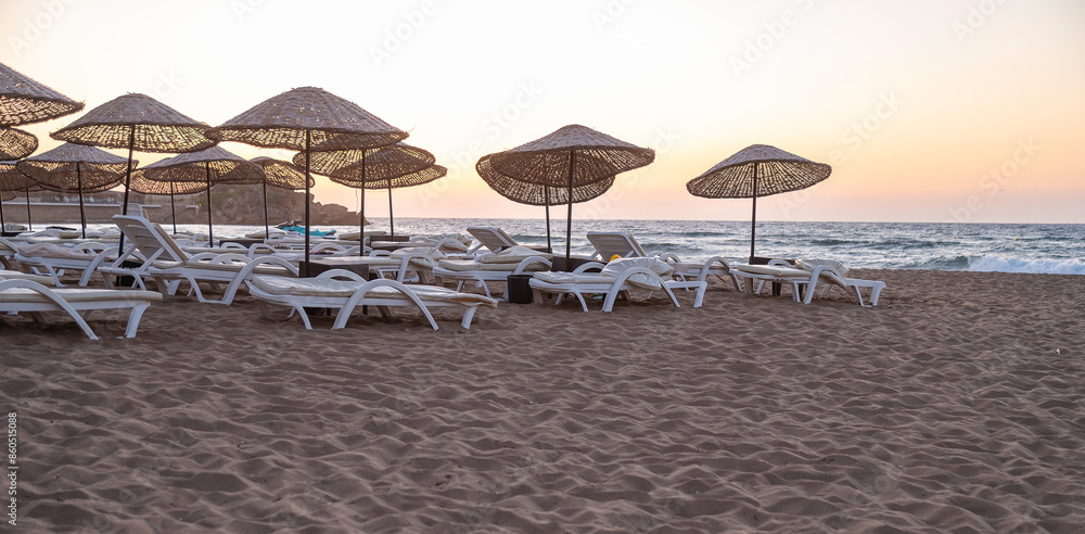 Empty sun loungers on the beach in evening time Empty sun loungers on the beach in evening time