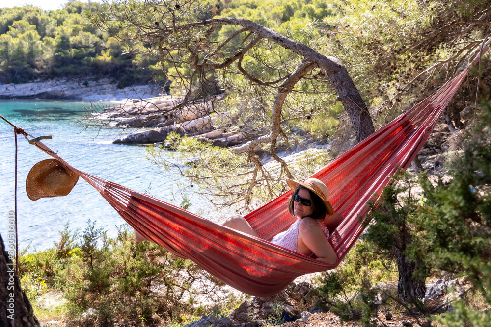 Woman in a hammock in Stupica Bay on the island of Zirje in Croatia