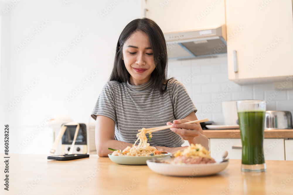Asian Girl eating Thai food in kitchen counter Home delivery food feeling happy Asian Girl eating Thai food in kitchen counter Home delivery food feeling happy