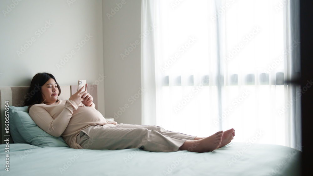 Pregnant woman using mobile phone searching for newborn baby preparation Pregnant woman using mobile phone searching for newborn baby preparation