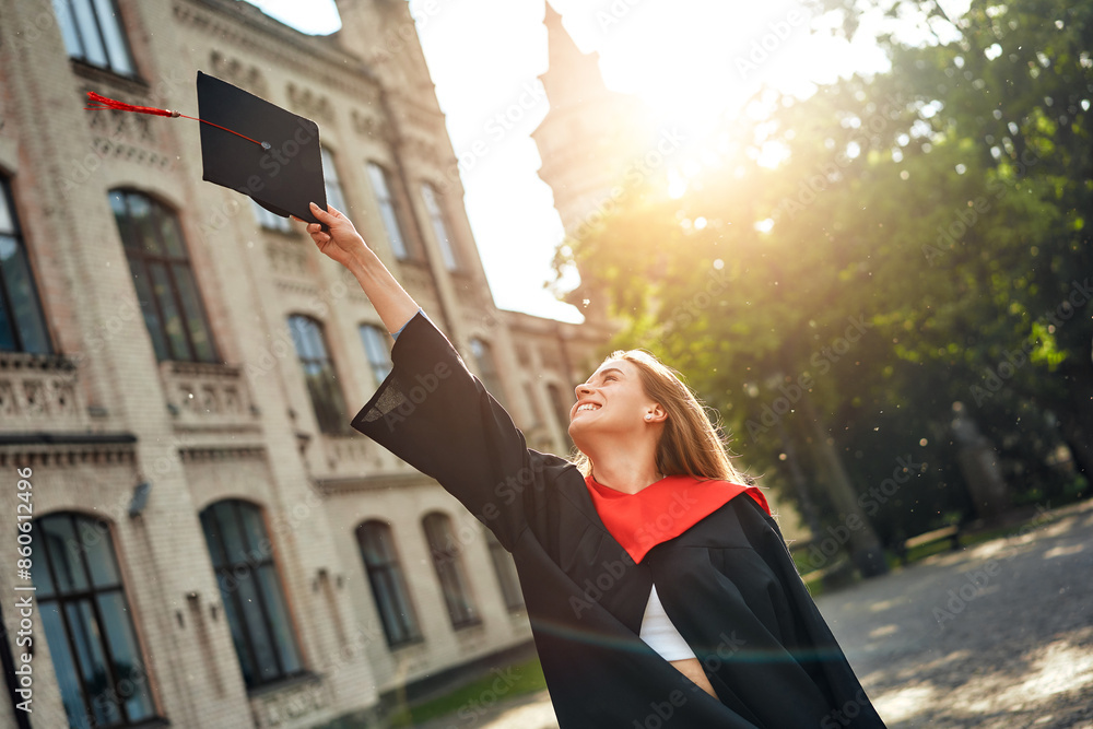 Fototapeta premium Young Graduate Celebrating Academic Achievement and Success at University Campus