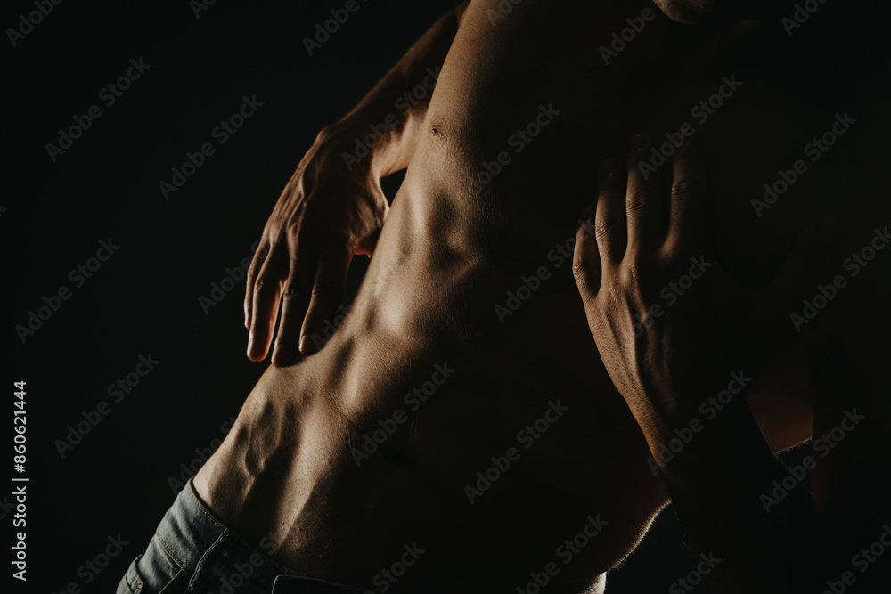 Close-up image showing a fit male torso with well-defined abs, highlighted by dramatic lighting. Emphasizes fitness, health, and muscular definition. Close-up image showing a fit male torso with well-defined abs, highlighted by dramatic lighting. Emphasizes fitness, health, and muscular definition.