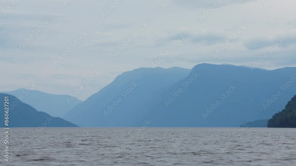 Looking out from the stern of a fast moving motor boat to it's large bright white wake which is reaching out to the distant mountains and clouds. Looking out from the stern of a fast moving motor boat to it's large bright white wake which is reaching out to the distant mountains and clouds.
