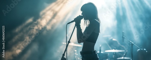 Backlit silhouette of a female singer performing on stage with a band, exuding a sense of music and drama