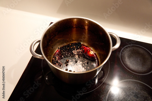 Large pot burned with chickpeas inside on the induction hob in the kitchen at home