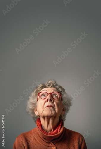 Elderly senior woman with glasses looking up to empty copy space above. Studio portrait vertical banner. Generative AI
