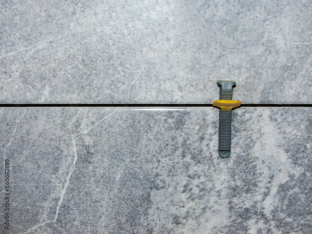 wedge and clamp in tile leveling system , laying gray marble effect porcelain tiles on the wall wedge and clamp in tile leveling system , laying gray marble effect porcelain tiles on the wall