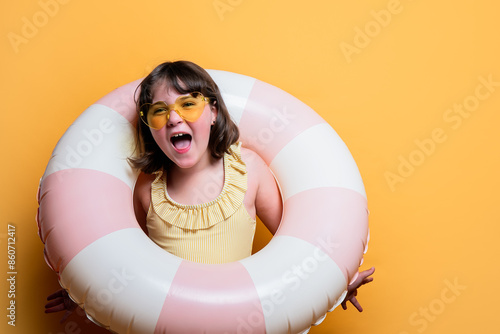 Joyful child with swim ring in a summer themed studio