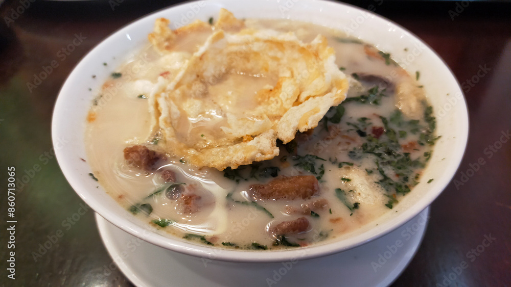 Traditional Indonesian Soto Betawi Soup with Creamy White Broth and Crispy Toppings in a Restaurant Setting Traditional Indonesian Soto Betawi Soup with Creamy White Broth and Crispy Toppings in a Restaurant Setting