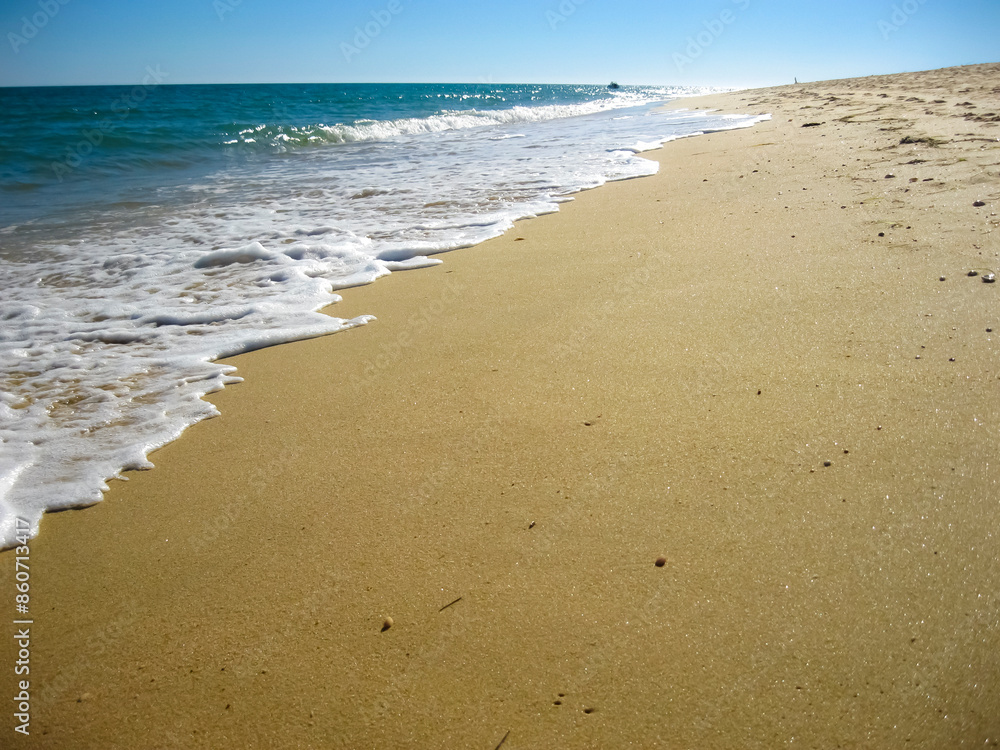 A scenic sandy beach where waves are crashing on the shore A scenic sandy beach where waves are crashing on the shore