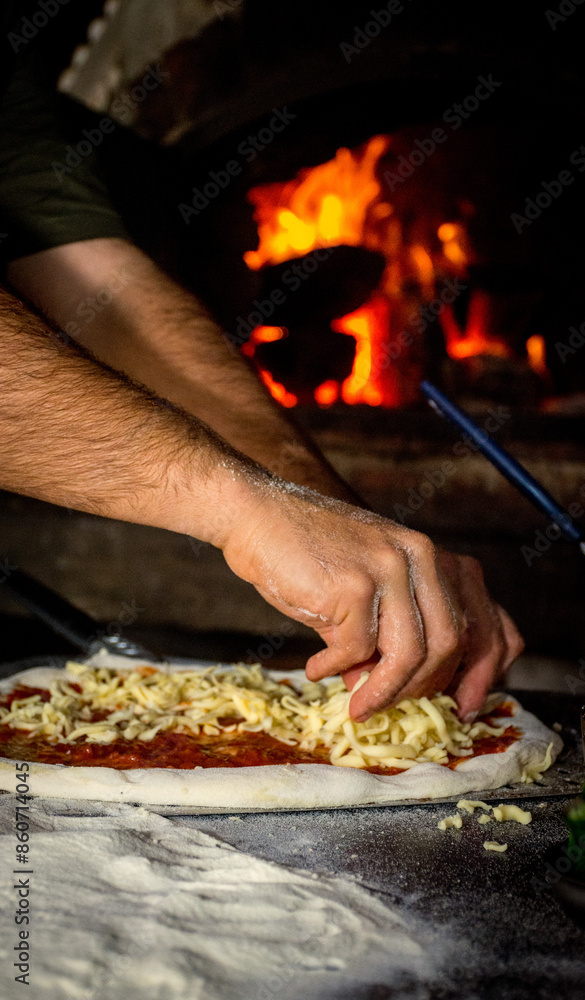 manos poniendo queso a la pizza manos poniendo queso a la pizza