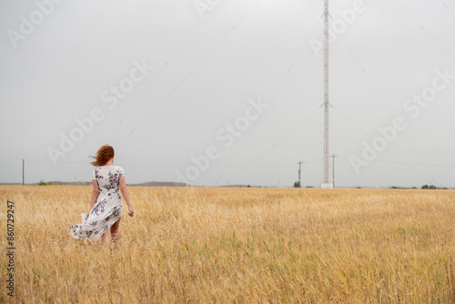 Solitary woman wanders in a vast wheat field