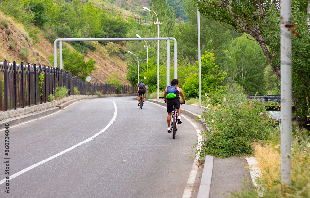 custom made wallpaper toronto digitalTwo Cyclists Riding Down a Winding Road in a Green Valley