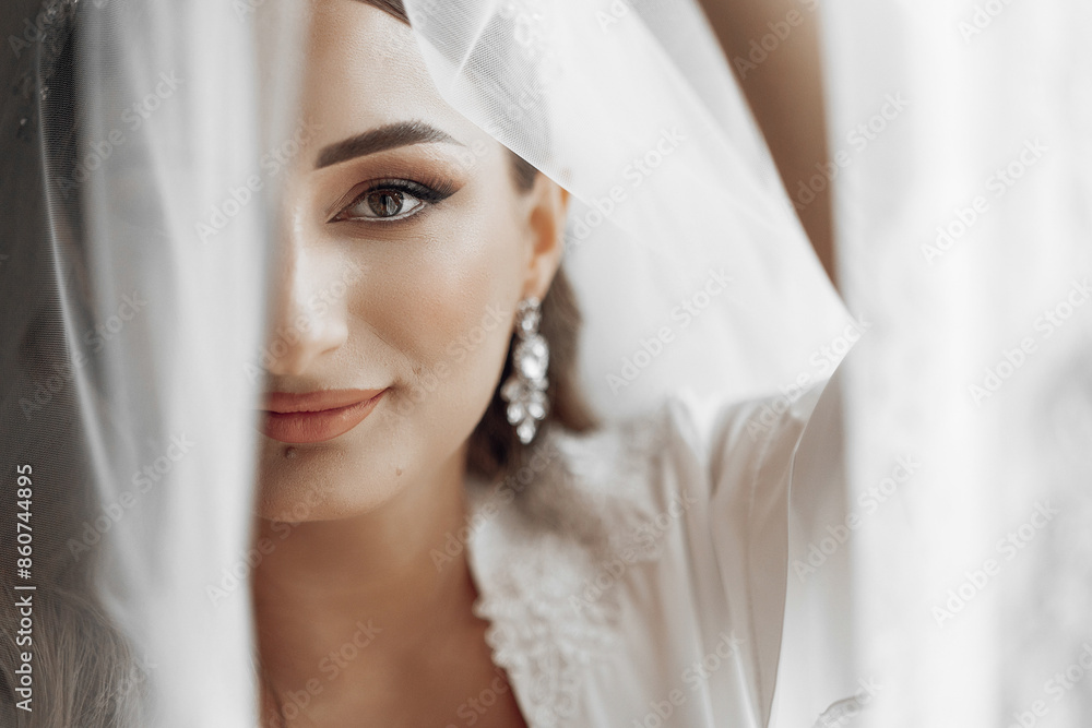 A woman with a veil over her face is wearing a white dress and earrings. Concept of mystery and elegance, as the woman's face is partially hidden by the veil A woman with a veil over her face is wearing a white dress and earrings. Concept of mystery and elegance, as the woman's face is partially hidden by the veil