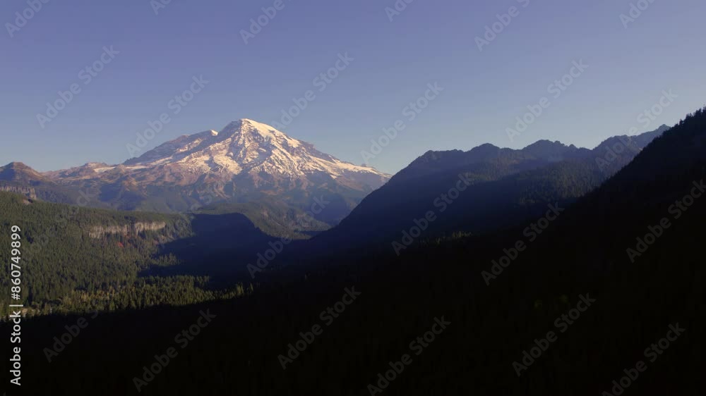 Snow-Capped Mountain Peak Rising Above a Forested Valley Snow-Capped Mountain Peak Rising Above a Forested Valley