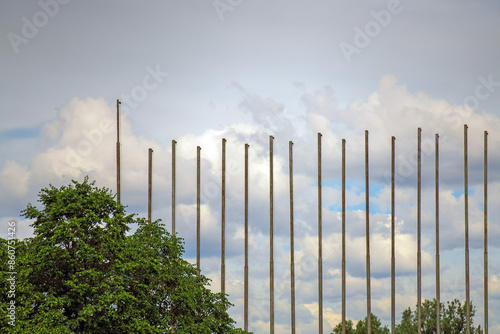 Row of empty flagpoles against a cloudy sky, a blank canvas for symbols and banners photo