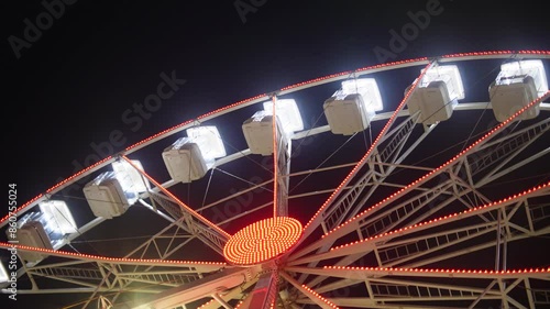Ferris Wheel. Scene of a brightly lit Ferris wheel in the evening, spinning against the night sky.