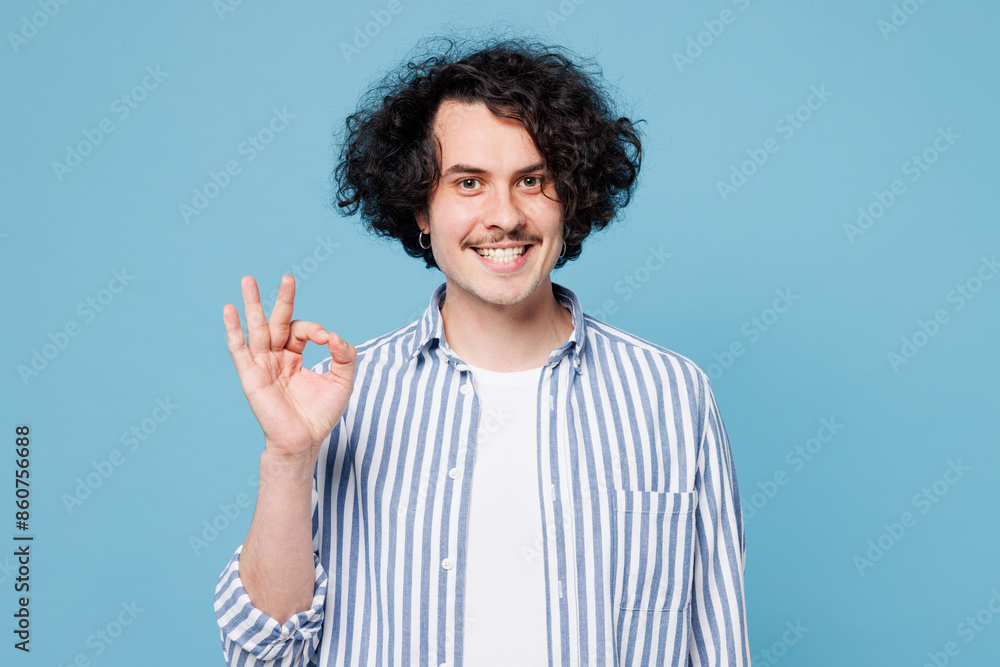 Young satisfied fun smiling happy cheerful man wear shirt white t-shirt casual clothes showing okay ok gesture isolated on plain pastel light blue cyan background studio portrait. Lifestyle concept Young satisfied fun smiling happy cheerful man wear shirt white t-shirt casual clothes showing okay ok gesture isolated on plain pastel light blue cyan background studio portrait. Lifestyle concept