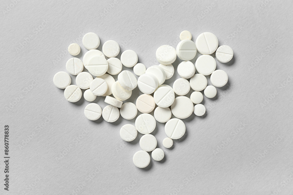Heart made of white pills on grey background Heart made of white pills on grey background