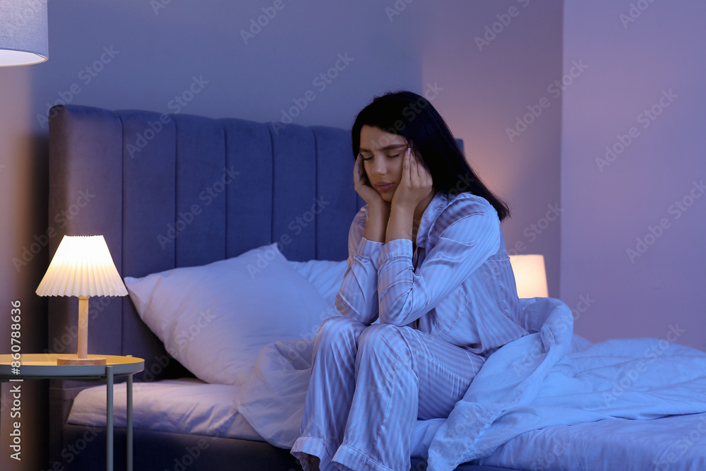 Fototapeta premium Beautiful young woman suffering from insomnia in bedroom at night