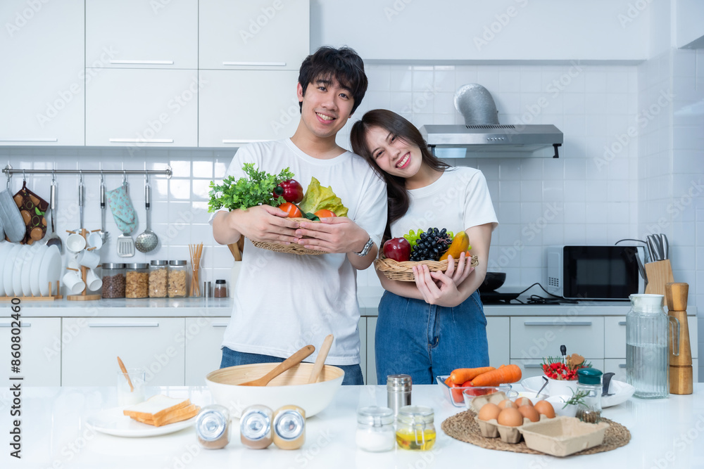 Happy portrait of loving young loving couple asian of having fun standing a cheerful preparing food and enjoy cook cooking with vegetables, meat, bread while standing on a kitchen Condo life or home Happy portrait of loving young loving couple asian of having fun standing a cheerful preparing food and enjoy cook cooking with vegetables, meat, bread while standing on a kitchen Condo life or home