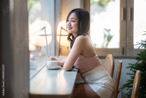 Portrait of beautiful happy Smiling asian woman relaxing sitting in cafe interior in coffee shop background,Business Lifestyle summer holiday concept