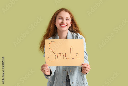 Young redhead woman holding...