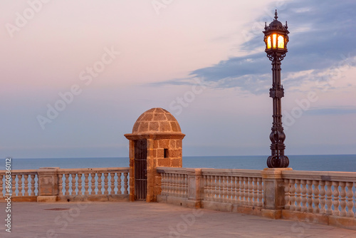 Stone observation fortification tower at dawn on the embankment in Cadiz, Andalusia, Spain