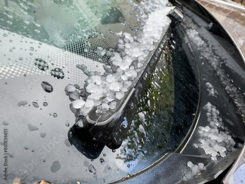 Photos Close-up of a car windshield covered in hailstones and raindrops, highlighting t