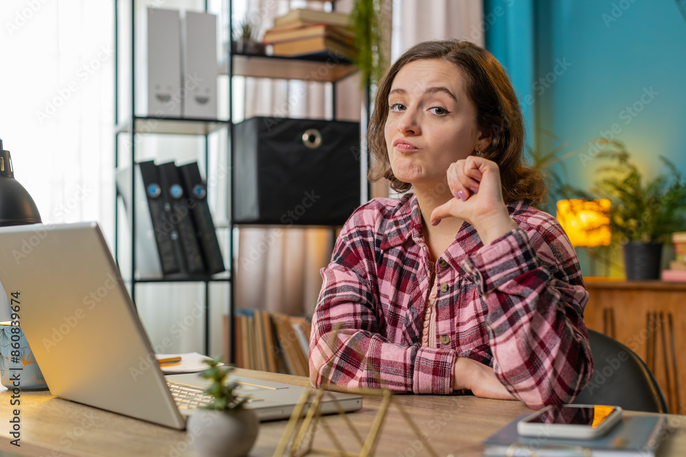 Dislike. Upset Caucasian businesswoman working on laptop computer at home table showing thumbs down sign gesture, expressing discontent, disapproval dissatisfied bad work. Displeased girl freelancer Dislike. Upset Caucasian businesswoman working on laptop computer at home table showing thumbs down sign gesture, expressing discontent, disapproval dissatisfied bad work. Displeased girl freelancer
