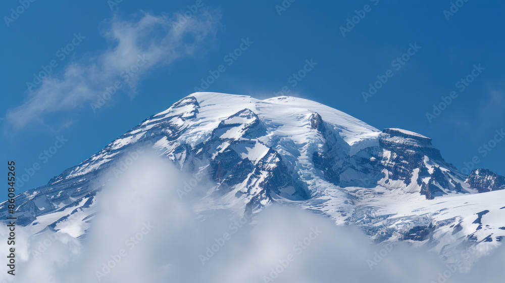 Snow-Capped Mountain Peak Amidst Fluffy Clouds and Blue Sky Snow-Capped Mountain Peak Amidst Fluffy Clouds and Blue Sky
