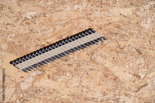 Quadro su tela Construction background, collated nail gun nails, connected with paper tape; on