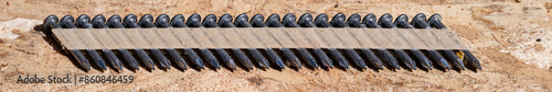 Foto Construction background, collated nail gun nails, connected with paper tape; on
