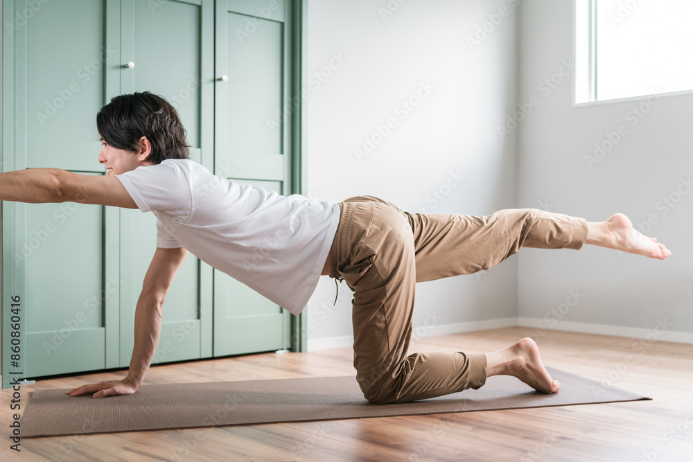 Fototapeta premium 家でヨガ・ピラティス・筋トレ・朝活する若いアジア人男性